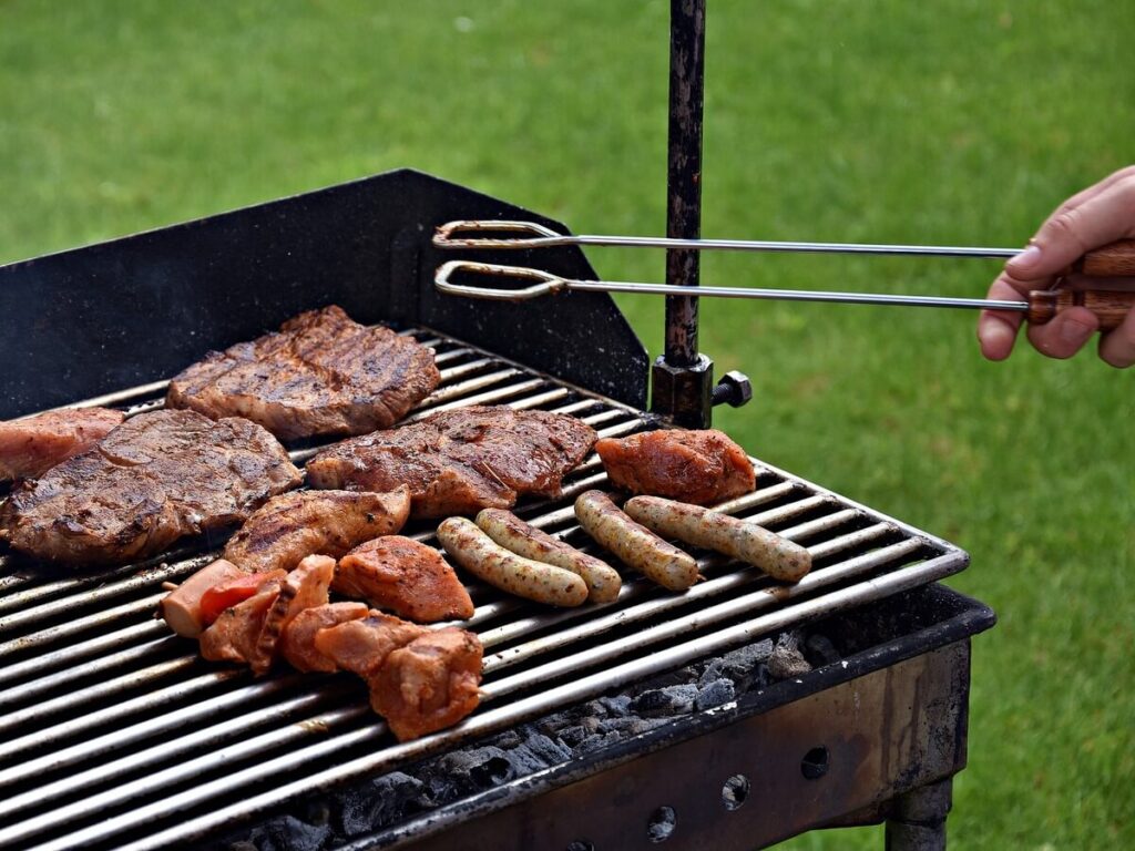 Accessori per barbecue; l'immagine mostra un barbecue in azione con varie tipologie di carne in cottura