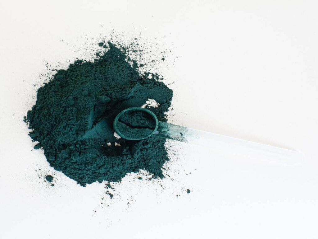 Spirulina in cucina; l'immagine ritrae la spirulina in polvere colore classico verde sparsa su un tavolo