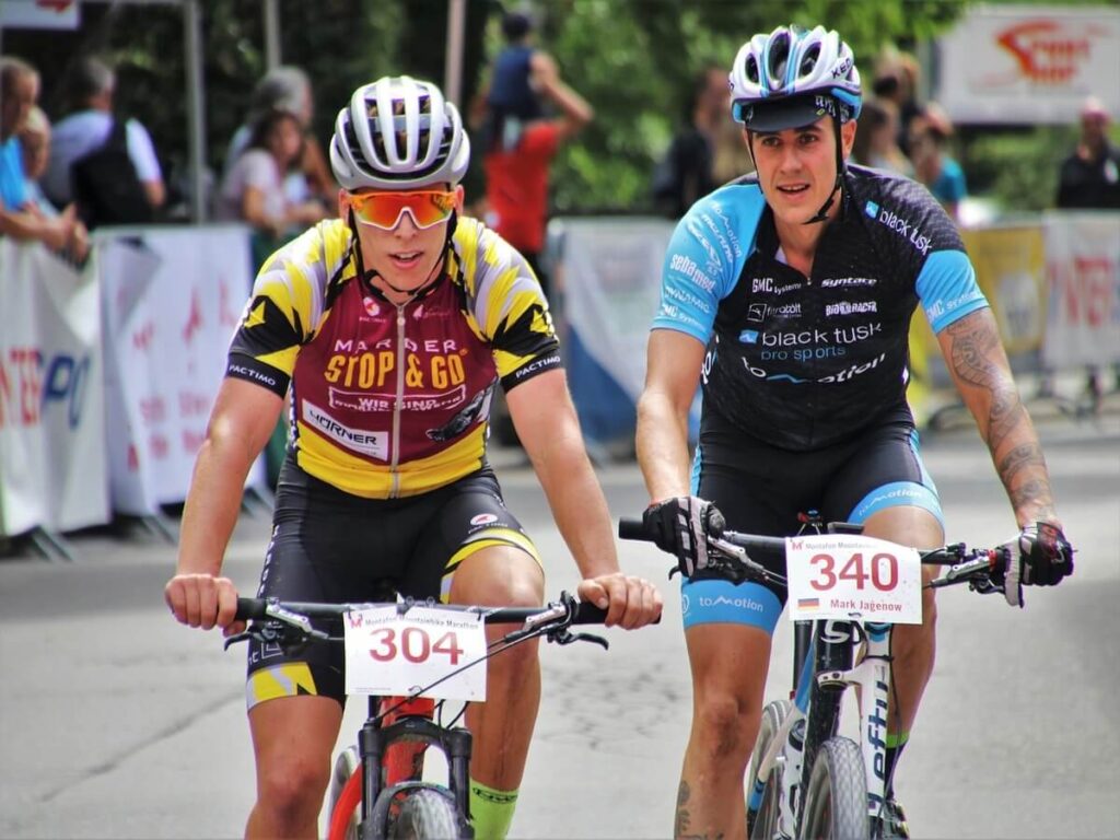 In questa foto vediamo 2 atleti ciclisti in una gara di mountain bike con un coloratissimo e performante abbigliamento bici
