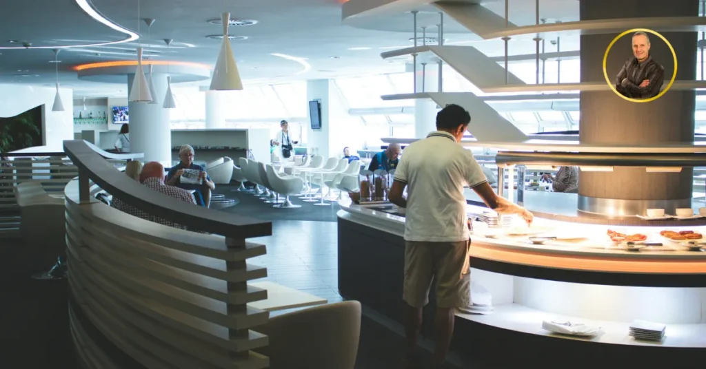 Carta Amex Oro 2026: La Guida Definitiva tra Lusso, Sicurezza e Bonus Esclusivo Carta Amex Oro 2026 - Interno di una lounge VIP aeroportuale moderna con area buffet illuminata, persone che si servono e logo di Michele Stedile.