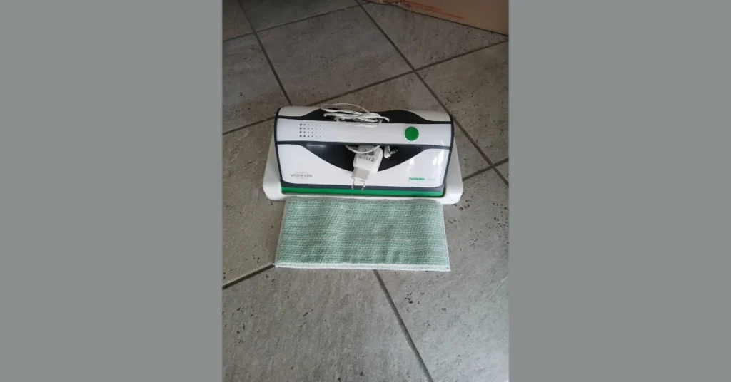 Folletto 2026 Opinioni: Perché dopo 5 anni resta il mio standard di igiene domestica Folletto 2026 opinioni - primo piano della macchina lavavetri vg100 appoggiata a terra con un panno colore verde